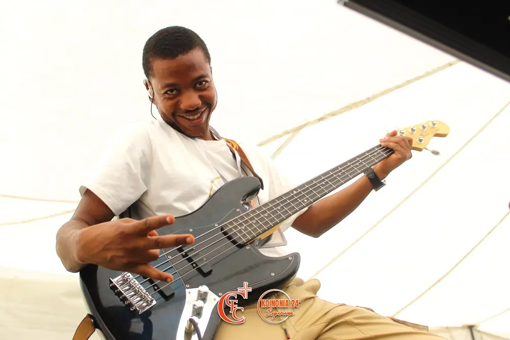 A bass player grinning on stage