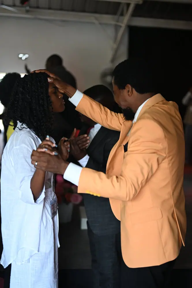 A leader praying over a delegate