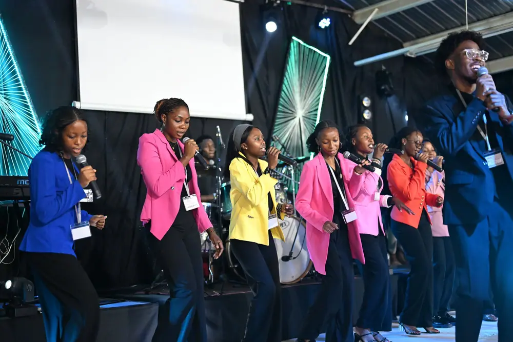 The choir in bright jackets singing across the stage
